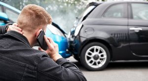 Photo of a man calling for help after a car accident